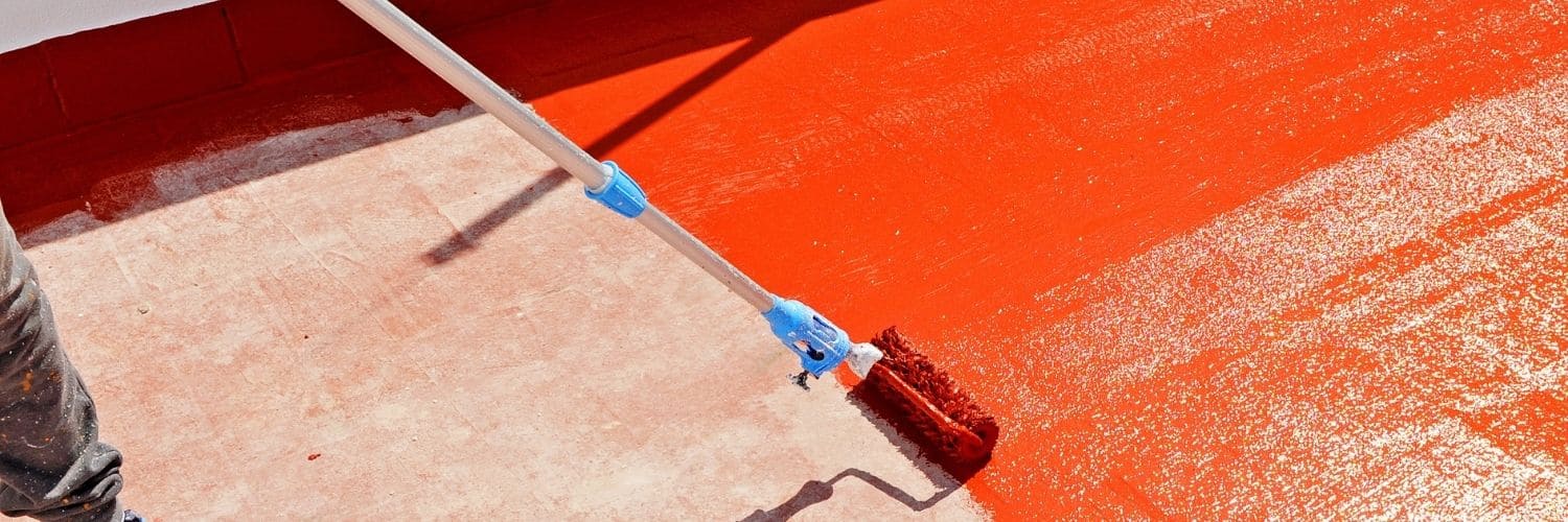 Aplicación de revestimiento impermeabilizante rojo en terraza exterior