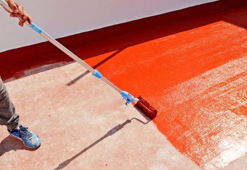 Aplicación de revestimiento impermeabilizante rojo en terraza exterior