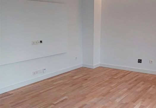 Salón con parquet recien pintado en blanco