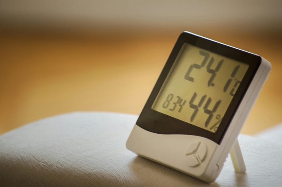 Higrómetro digital midiendo temperatura y humedad en interior de vivienda
